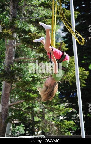 Ein junges Mädchen genießt dabei einen Purzelbaum auf dem Bungee Trampolin in Snowbird Stockfoto