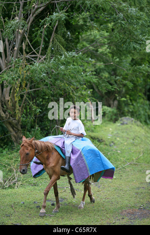 Ein Junge auf seinem Pferd in der Nähe von Laguna Charco Verde. Isla de Ometepe, Rivas, Nicaragua, Mittelamerika Stockfoto