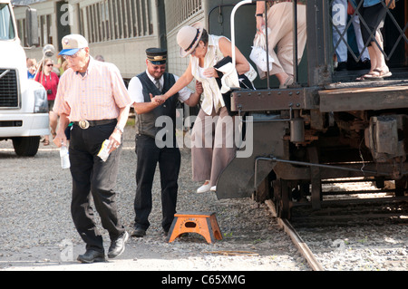 Begleiter helfen Senioren aus Waggon. Stockfoto