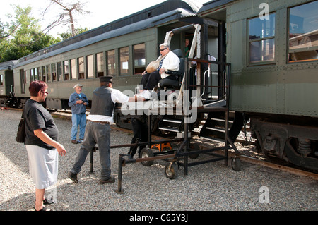 Begleiter helfen Senioren aus Waggon. Stockfoto