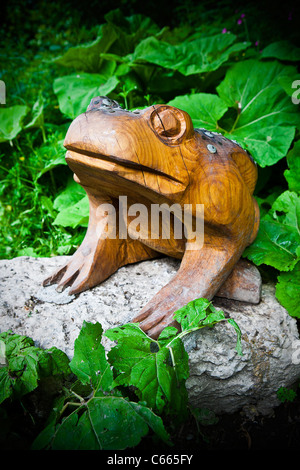 Ein geschnitzten Frosch sitzt auf einem Blatt bedeckt Felsen auf Kriegsfuß Country Park in Nord-Wales Stockfoto