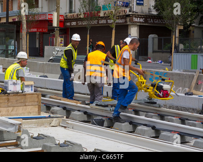 Paris, Frankreich, Kleingruppen, Bauarbeiter afrikanische Einwanderer, Installation von Bahngleisen auf der Straße für Straßenbahnen, Internationale Einwanderer Europa, Einwandererarbeit, schwarze Gemeinde Paris, Einwandererarbeiter frankreich, Arbeiter, Vielfalt am Arbeitsplatz Stockfoto