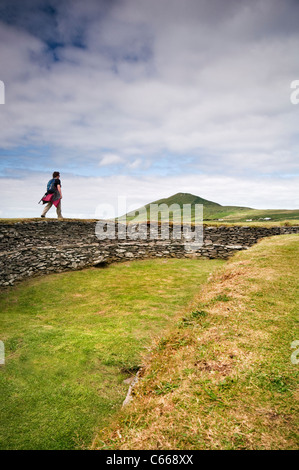 Ein Tourist zu Fuß entlang der Wände des Leacanabuile Stone Fort in der Nähe von Cahirciveen in County Kerry, Irland Stockfoto