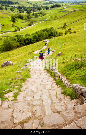 Wanderer, die ihren Weg nach unten den Weg bis zu dem Kalkstein Pflaster über Malham Cove in den Yorkshire Dales, England Stockfoto