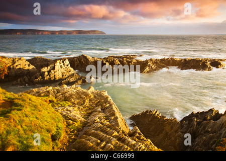 Abendlicht fällt auf den Felsen von Barricane Strand, Woolacombe, mit Blick in Richtung Baggy Point, North Devon, England, UK Stockfoto