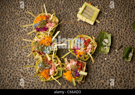 Flache Aufnahme von Canang Sari - tägliches balinesisches Hindu-Angebot, um der Sang Hyang Widhi Wasa zu danken, auf einem Bürgersteig in Kaution Stockfoto