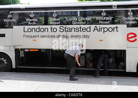 Flughafen Stansted National Express Bus Service & Treiber helfen Passagier Sammeln Gepäck Koffer bei der Ankunft in London, England, Großbritannien Stockfoto