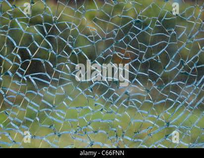 Ein Blick durch ein zerbrochenes Fenster auf einem Pastell grünen Hintergrund Stockfoto