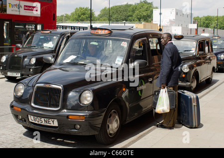 Gentleman warten draußen ein Black Cab in London, England. Stockfoto