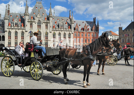 Provinzielle Gericht und Touristen in Pferdekutsche für Sightseeing-Tour auf dem Marktplatz / Grote Markt in Brügge, Belgien Stockfoto