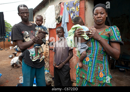 Eine Familie steht vor ihrem Haus in einem Slum in Bamako, Mali, Westafrika. Stockfoto