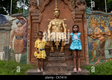 Kleine Kinder stehen neben einer Statue in Phnom Penh, Kambodscha. Stockfoto