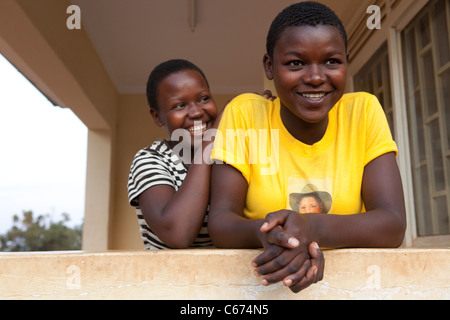 Schulmädchen warten draußen ein Gesundheitszentrum in Kampala, Uganda, Ostafrika. Stockfoto