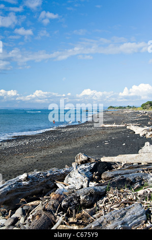 Die schwarzen Sand- und Stein Strand mit Blick auf die weißen Klippen mit der Tasmansee Taranaki Region Neuseelands Waitara NZ Stockfoto