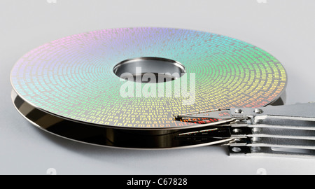 Teile der Festplatte im grauen Hintergrund mit symbolisierten Informationen auf magnetischen Oberfläche Stockfoto