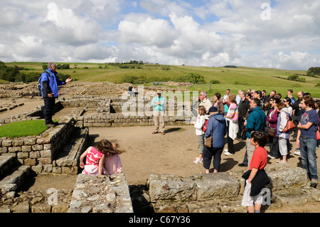 Führer im Gespräch mit Touristen aus dem Tribunal in Hochhaus, in der römischen Festung von Vindolanda, in der Nähe der Hadrianswall, UK Stockfoto