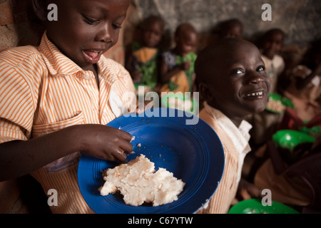 Junge Schulkinder Essen Posho oder Ugali, an einer Schule in Amuria, Uganda, Ostafrika. Stockfoto