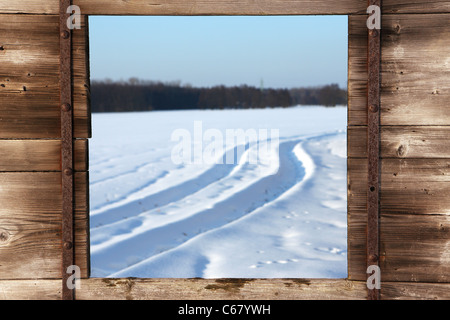 Blick vom Holzfenster über verschneite Winterlandschaft Stockfoto