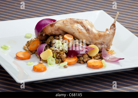 Gebratene Kaninchenkeule mit Linsen und Gemüsebeilage Stockfoto