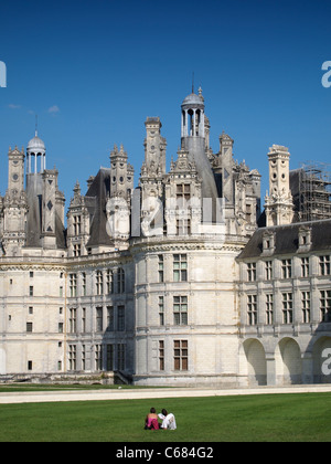 Paar, sitzen in der Wiese bewundern herrlichen Chateau Royal de Chambord, Loiretal, Frankreich Stockfoto