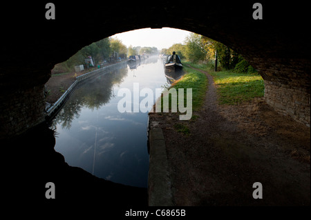 Blick durch eine Brücke am Kanalboote an einem nebligen Morgen. Aynho Wharf, Oxfordshire, England Stockfoto