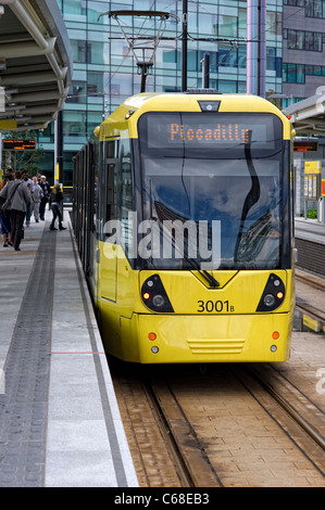 Eines der modernen gelben Straßenbahnen, stehend auf einer Plattform an der MediaCityUK Station in Salford Quays (Bestandteil der Metrolink-System) Stockfoto