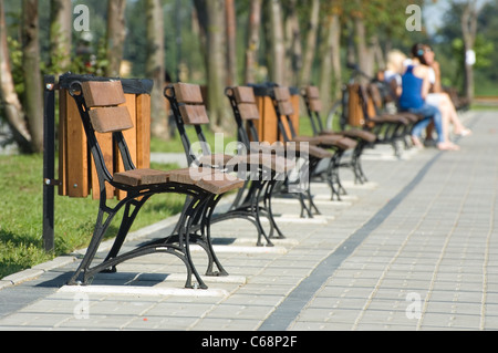 Metallische und hölzerne Bänke im park Stockfoto