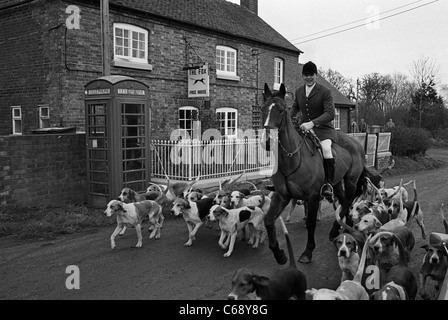 Huntsman, Pferd und Hund bereiten sich auf eine Fuchsjagd vor dem Fox Inn, Marston, Staffordshire, England, vor. Vintage Schwarz-Weiß-Bild Stockfoto