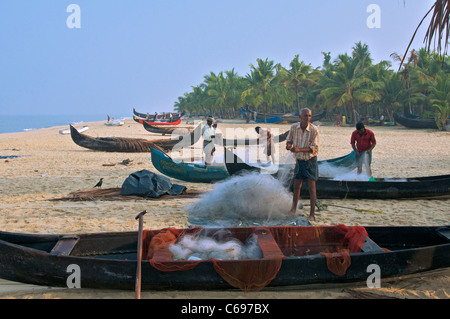 Fischer, die Sortierung Fischernetze auf Marari Beach Kerala Süd-Indien Stockfoto