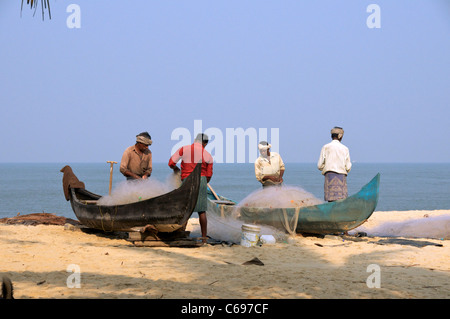 Fischer, die Sortierung Fischernetze auf Marari Beach Kerala Süd-Indien Stockfoto