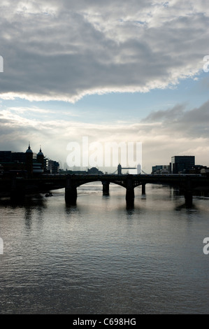 Am frühen Morgen Blick auf die Themse, London mit stürmischen Himmel von Millennium Bridge zeigt Southwark Bridge und der Tower Bridge Stockfoto