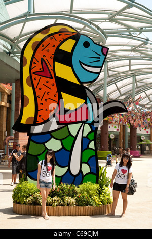 Zwei lokale Mädchen posieren vor eine Anpassung der Merlion, Singapurs Symbol in den Universal Studios Singapur Stockfoto