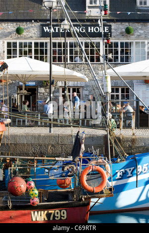 Die blaue-weiße Rumpf des FY95 Fischerboot und The Watering Hole spiegelt sich in dem Wasser bei Sutton Harbour, Barbican, Plymouth. Stockfoto