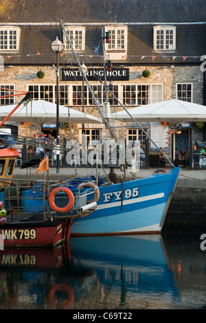 Die blaue-weiße Rumpf des FY95 Fischerboot und The Watering Hole spiegelt sich in dem Wasser bei Sutton Harbour, Barbican, Plymouth. Stockfoto