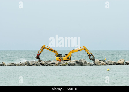 Ein paar Bagger bauen ein künstliches Riff, Teil des Meeres Abwehrkräfte für das Dorf von Borth, Ceredigion, Wales Stockfoto