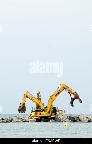 Drei Bagger bauen ein künstliches Riff, Abwehrkräfte Teil des Meeres für das Dorf von Borth, Ceredigion, Wales Stockfoto