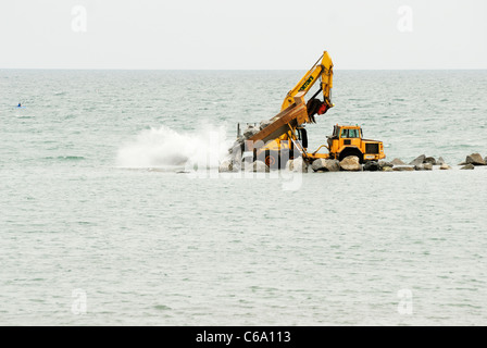 LKW Kipp Stein für den Bau von ein künstliches Riff, Abwehrkräfte Teil des Meeres für das Dorf von Borth, Ceredigion, Wales Stockfoto