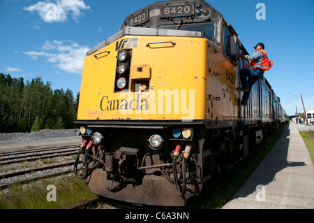 Ein Zugbegleiter montiert eine Lokomotive, die einen Personenzug in der nordkanadischen Stadt Thompson, in Manitoba, Kanada zieht. Stockfoto