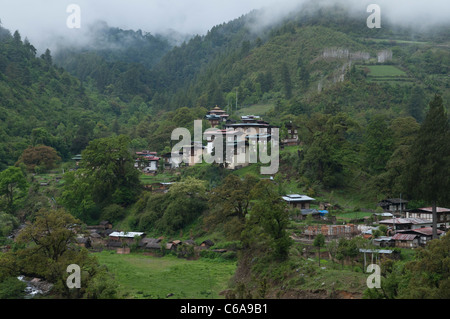 Blick auf typischen Dorf umgeben von Hügeln und Wäldern. Bhutan Stockfoto