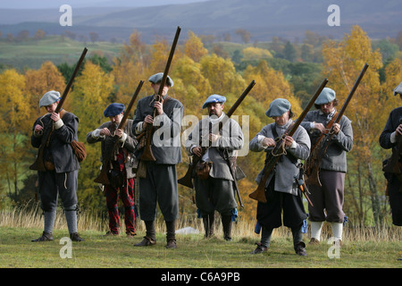 Mitglieder des [Frasers Dragoner], ein 17. Jahrhundert Reenactment Gesellschaft, laden ihre Musketen Stockfoto