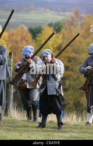 Mitglieder des [Frasers Dragoner], ein 17. Jahrhundert Reenactment Gesellschaft, laden ihre Musketen Stockfoto