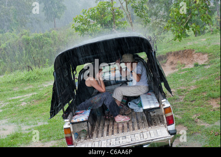 Zwei Frauen Zuflucht von Starkregen auf der Rückseite ein 4 x 4 Fahrzeug Thailand Asien Stockfoto