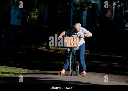 Ältere Frau auf dem Fahrrad, London Fields Park, Hackney, London, UK Stockfoto
