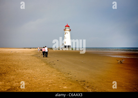 Menschen zu Fuß entlang des Strandes in der Nähe von Punkt von Ayr Leuchtturm auf Talacre Strand in Flintshire, Nordwales Stockfoto