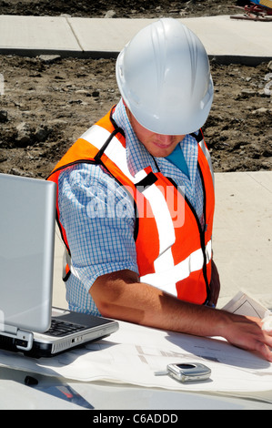 Architekten vor Ort prüfen von Zeichnungen auf seinem Laptopcomputer Stockfoto