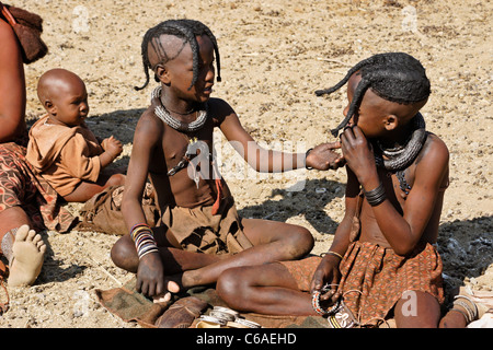 Himba-Mädchen und Baby im Dorf in der Nähe von Opuwo, Namibia Stockfoto