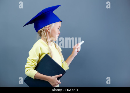 Porträt von schönen Mädchen in Graduation Hut schreiben mit Kreide Stockfoto