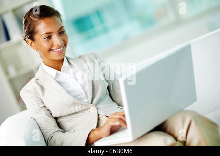 Porträt von lächelnden Geschäftsfrau mit Laptop im Büro Stockfoto