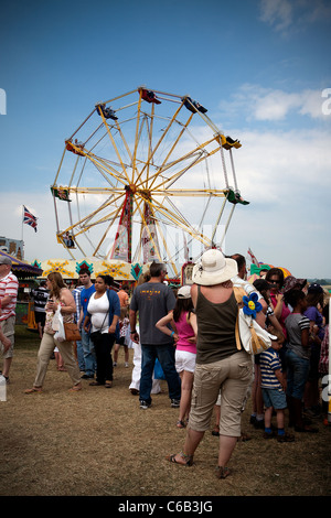 Menschen auf die Hollowell Dampf & Heavy Horse Show mit einem Riesenrad im Hintergrund Stockfoto