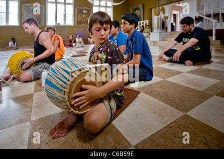 Anbeter zu chanten, während ein Junge spielt das Spiel auf ein Harmonium und eine "Mirdanga" während der Gottesdienste in einem hinduistischen Tempel in Laguna Trommel Stockfoto